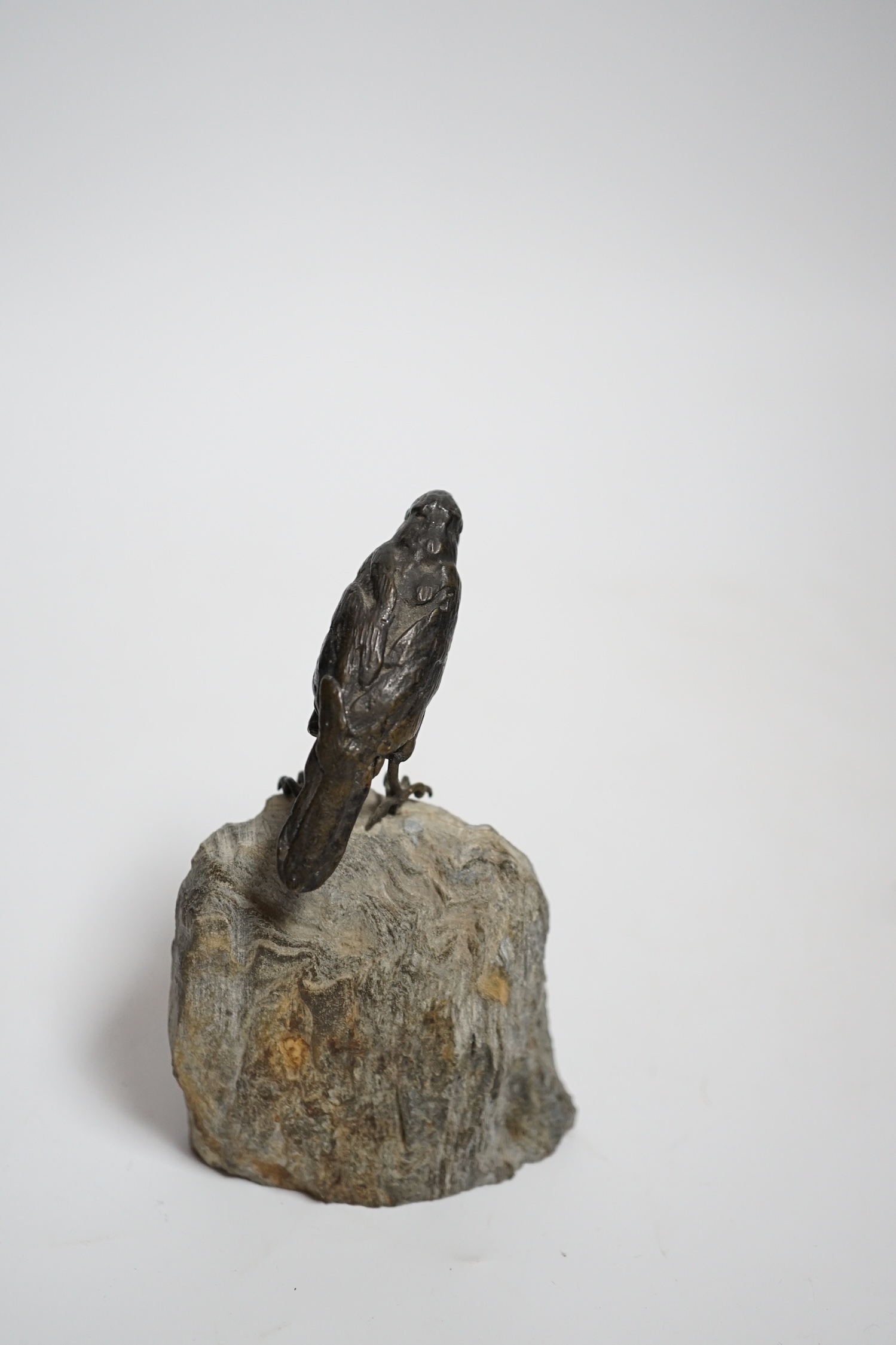 A cold painted bronze crow, raised on a stone base, 10cm high